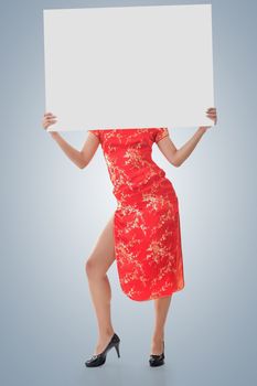 Attractive Chinese woman dress traditional cheongsam and hold blank board, full length portrait.