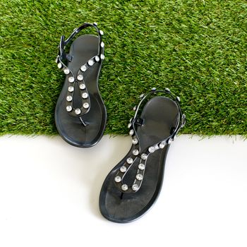 Sandals with rhinestones on green grass. View from above. Isolate on white.