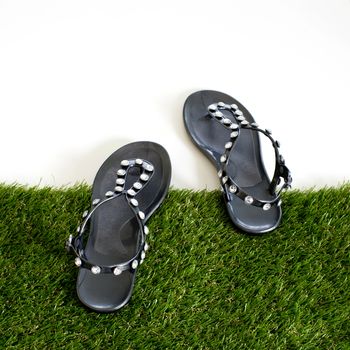 Sandals with rhinestones on green grass. View from above. Isolate on white.