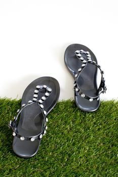 Sandals with rhinestones on green grass. View from above. Isolate on white.