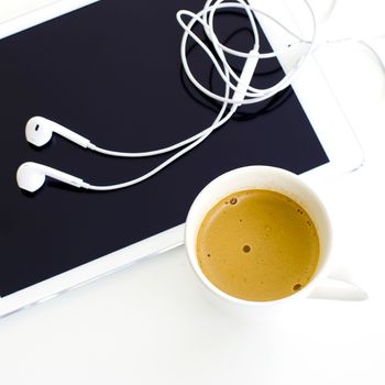 Digital tablet and earphone and white coffee cup on white background