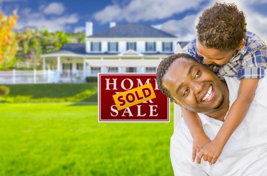 Happy Mixed Race Father and Son In Front of Sold Real Estate Sign and New House.