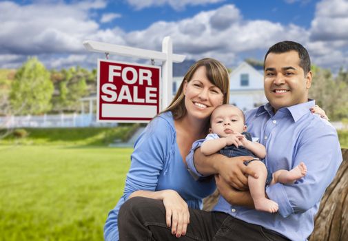 Happy Young Mixed Race Family in Front of For Sale Real Estate Sign and New House.