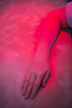 Hand, forearm and arm of injured patient receiving treamente under red physiotherapy rehabilitation hospital clinic heat lamp. 