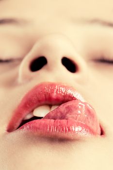 Beautiful woman seductively licking lips