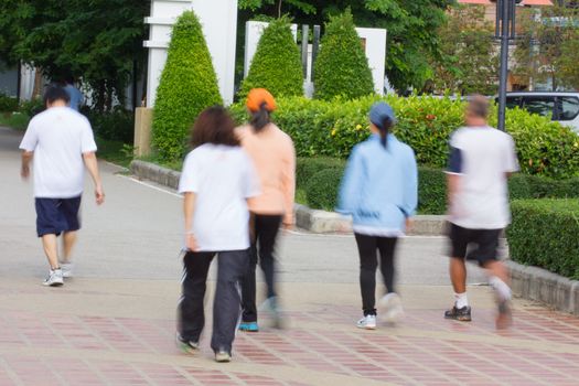 Blurred image of people walking in a park, outdoor exercise