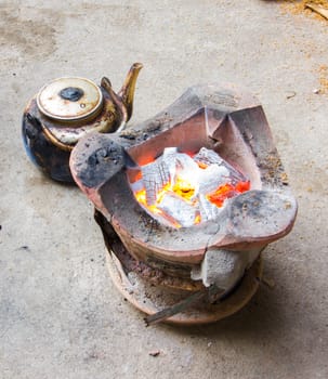 Thai traditional stove and wood burning inside with old kettle