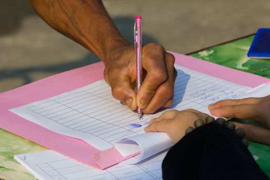 Thai farmer's hands signing a contract.