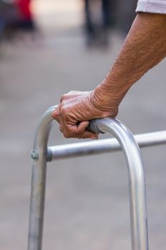 Closeup of an old man's hand using walking frame