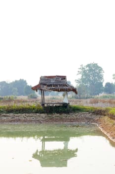 The fishing hut along the fish pond with reflection