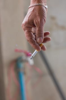 a close-up of a hand holding a cigarette