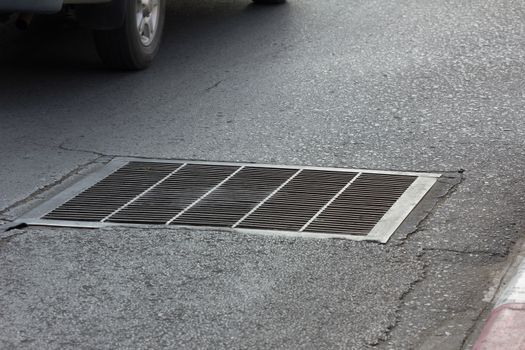 Drain grating on road in Thailand