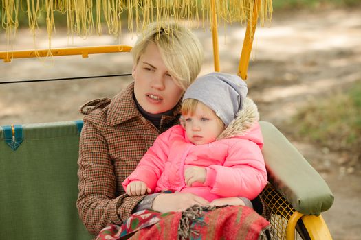 Beautiful Mother And Baby outdoors. Nature. Beauty Mum and her Child playing in Park together. Outdoor Portrait of happy family. Joy. Mom and Baby