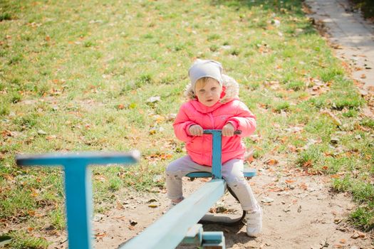 attractive little girl on outdoor playground equipment