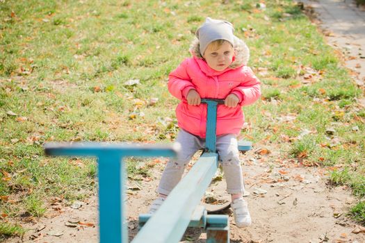 attractive little girl on outdoor playground equipment