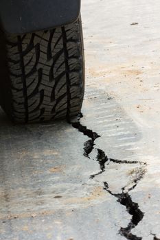 back view of tire tread and cracked asphalt