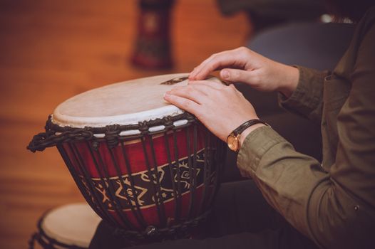 person playing on Jambe Drum no face 