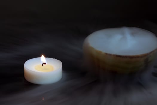 A candle with a pot of dry ice.