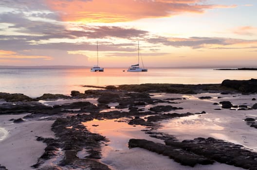 Catamarans at sunset offshore from Cabbage Tree Beach, Jervis Bay NSW Australia.  Feeling like a castaway on a deserted beach