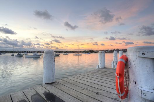 The timber pier at Leichhardt Park views over Iron Cove and moored boats at sunset