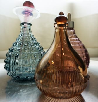 Colorful perfume bottles made from beautiful crystal, was placed on the table in the bedroom.                               