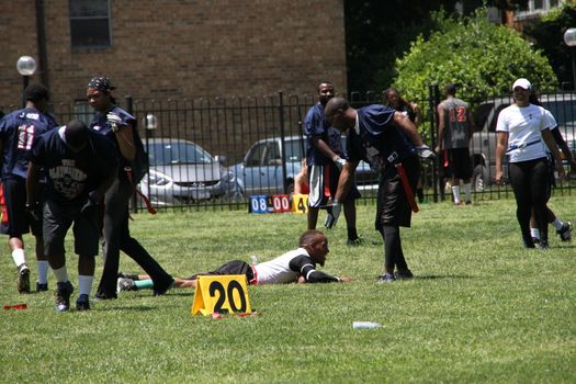 Washington DC, USA - may 19, 2012. African Americans play a game near the College. Honest sport one athlete fell, and the other helps him to rise
