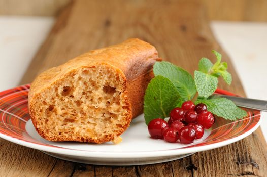 Homemade cake with cranberries and mint on old wood background