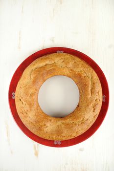 Homemade wreath cake on red plate with white space background