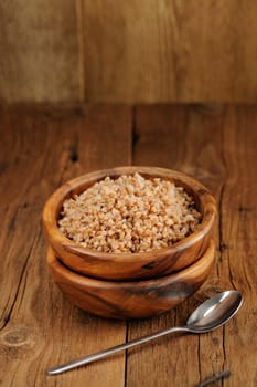 Russian buckwheat kasha in wooden bowl with space background