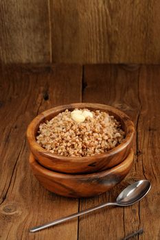 Russian buckwheat kasha in wooden bowl with space background