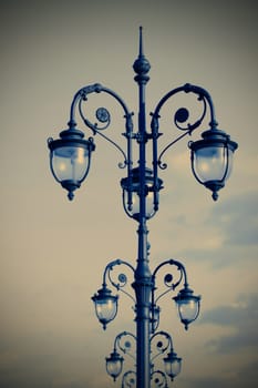 forged street lamps in the art deco style on sky background, instagram image style