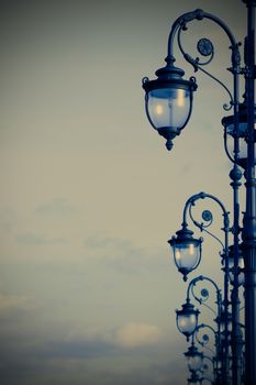 forged street lamps in the art deco style on sky background with copy-space, instagram image style