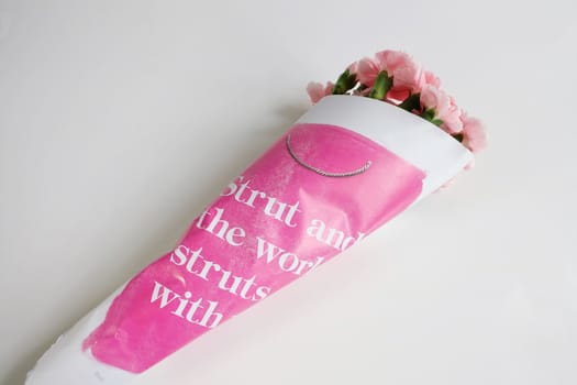 Bouquet of pink carnations wrapped in paper