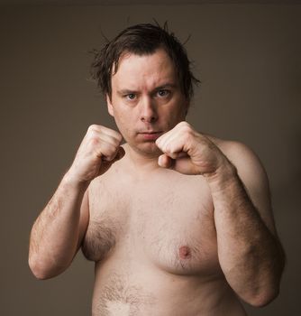 Naked man holding up his hands trying to fight