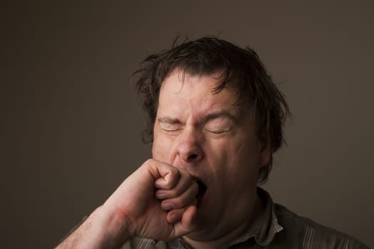 man who is either yawning or sneezing