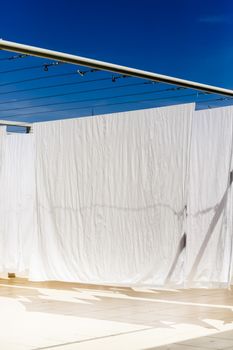 White clothes hanging on the line against blue sky.