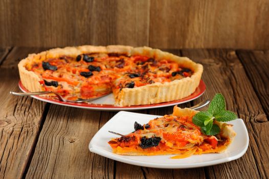 Tomato tart with olives on wooden background horizontal