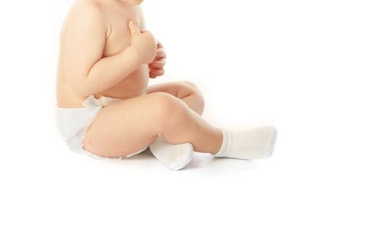 Little unrecognizable child in pampers and socks on a white background