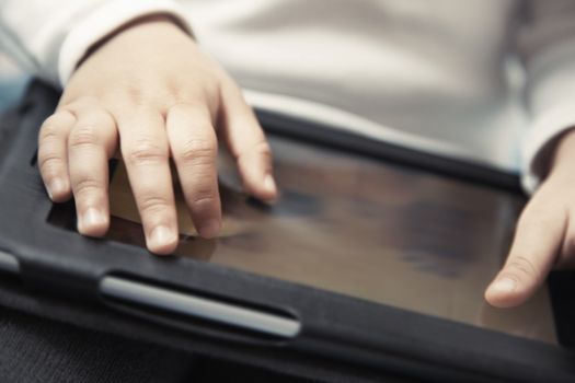 Hands of baby with digital tablet