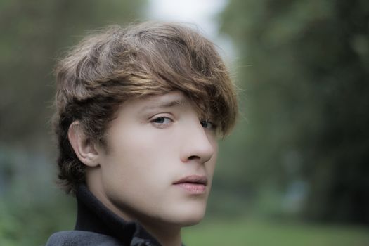 moody looking young man in outdoor setting