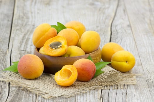 fresh apricots in a bowl on wooden background