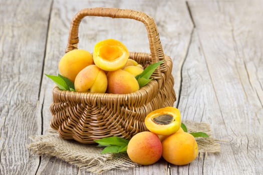 fresh apricots in a basket on wooden background