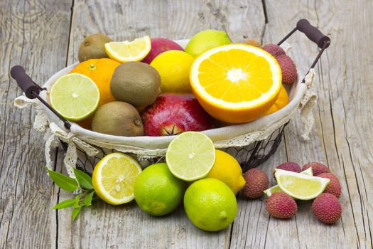 fresh fruits in a basket on wooden background