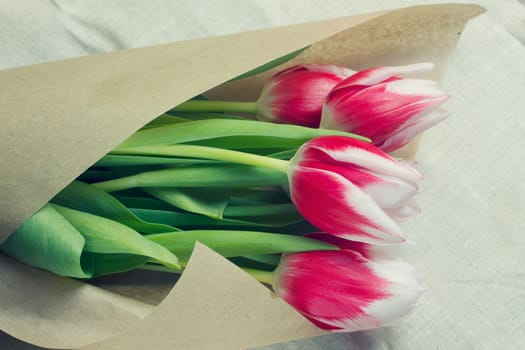 Bouquet of red tulips in multiples of parchment