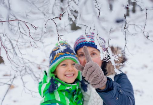 Portrait of a little boy with his mother in the snow