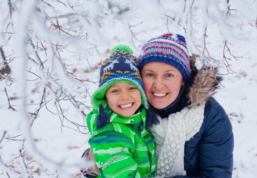 Portrait of a little boy with his mother in the snow