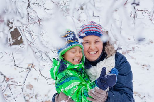 Portrait of a little boy with his mother in the snow