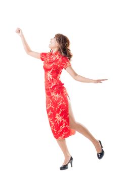 Smiling and excited Chinese woman dress traditional cheongsam at New Year, studio shot isolated.