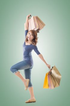 Cheerful shopping woman of Asian holding bags, isolated.