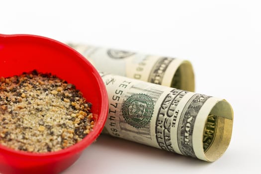 Cracked pepper, ground garlic, and other spices in red scoop with American currency in background